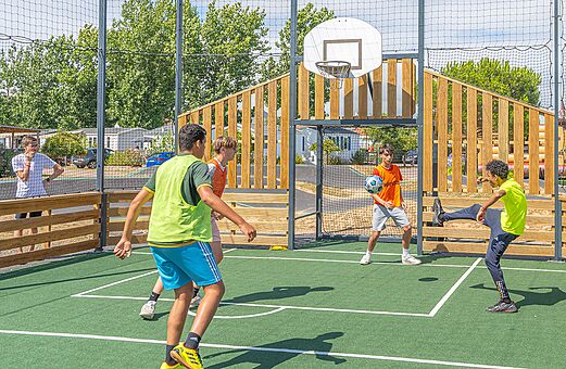 Multisportplatz, Jugendliche spielen Fu�ball, Camping VAGUES OCEANES Blancs Ch�nes.