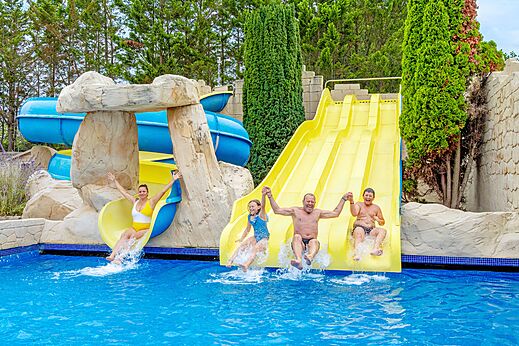 Familie auf Wasserrutschen und Au�enpool auf dem Campingplatz VAGUES OCEANES Bois Joly in Saint-Jean-de-Monts.