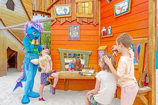 Kinder und Maskottchen im Spielbereich auf Camping VAGUES OCEANES Bois Joly in Saint-Jean-de-Monts.