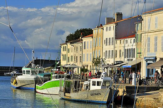Lebhafter Fischerhafen mit Booten und farbigen Fassaden in La Rochelle.
