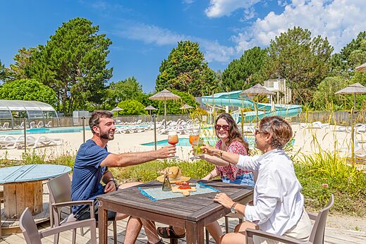 Familie stößt an der Bar an, Pool und Rutsche Camping CLICOCHIC Bordénéo Belle-Île.
