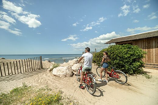 Fietsend koppel op strand bij camping CAPFUN Boucanet in LE GRAU DU ROI (30).