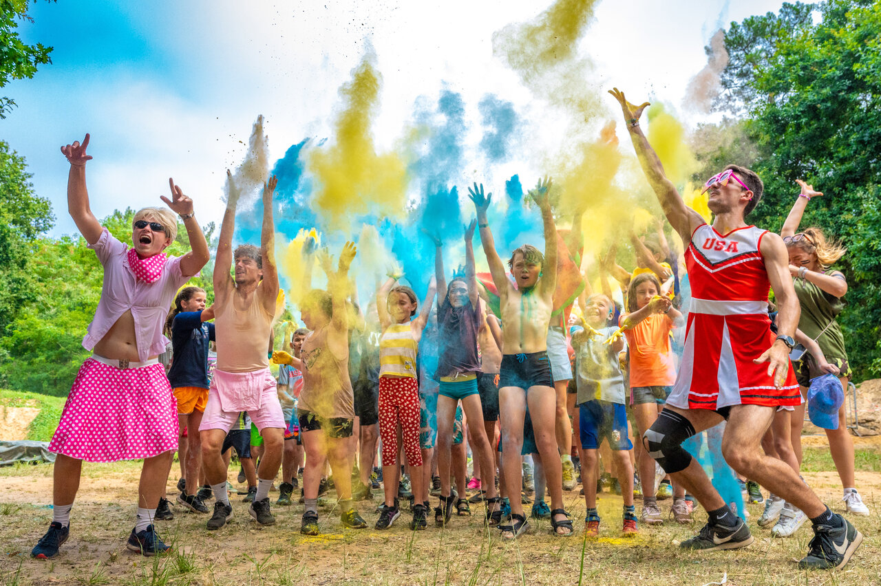 Colorful Holi-style animation with joyful participants at VAGUES OCEANES Boudigau campsite.