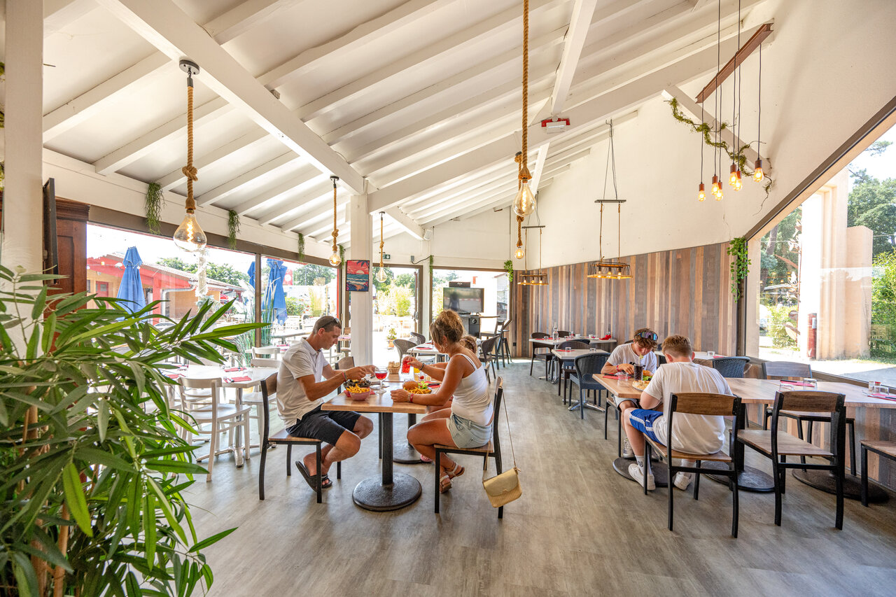 Modern indoor restaurant, guests dining at VAGUES OCEANES Boudigau campsite, LABENNE.