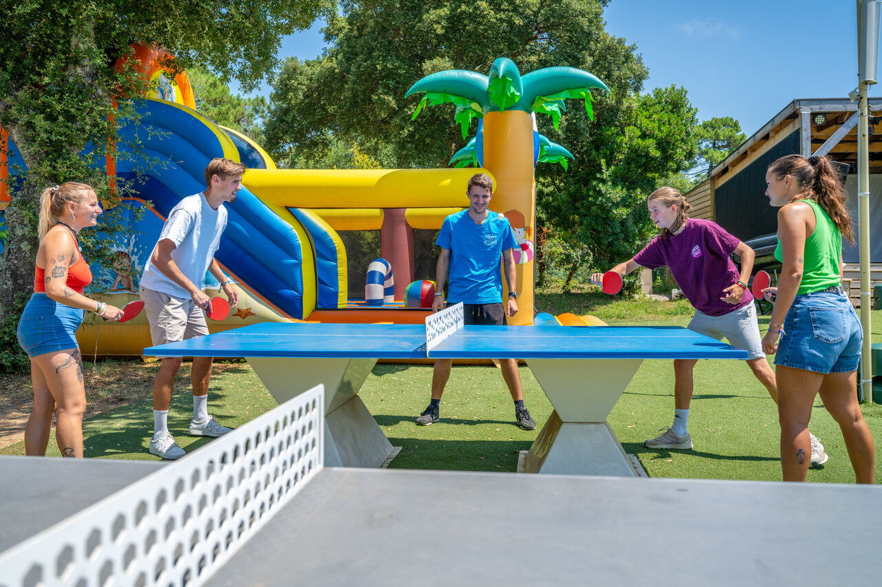 Young people playing table tennis near inflatable games at VAGUES OCEANES Boudigau campsite in LABENNE OCEAN (40).