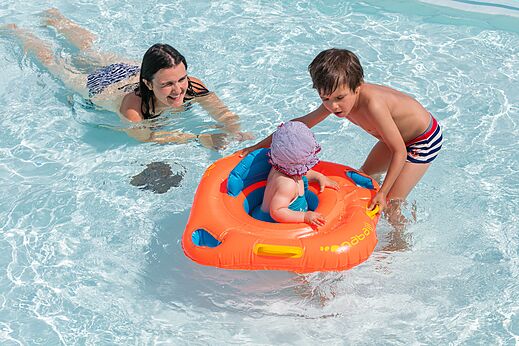 Familienpool mit Baby im Schwimmring am Campingplatz CLICOCHIC Brandais in Brem sur Mer.