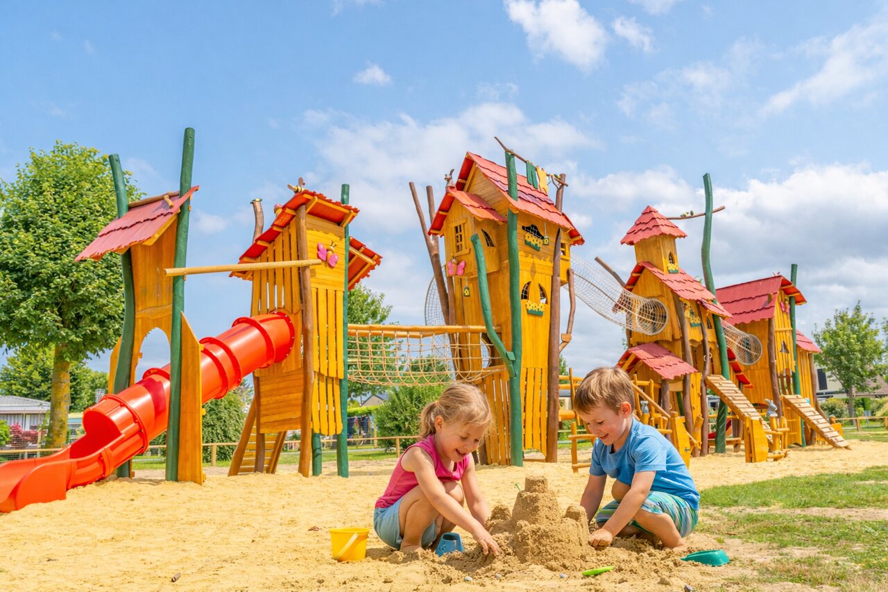 Kinder spielen im Sandkasten, Holzspielplatz auf Campingplatz CLICOCHIC Brise de Cabourg.