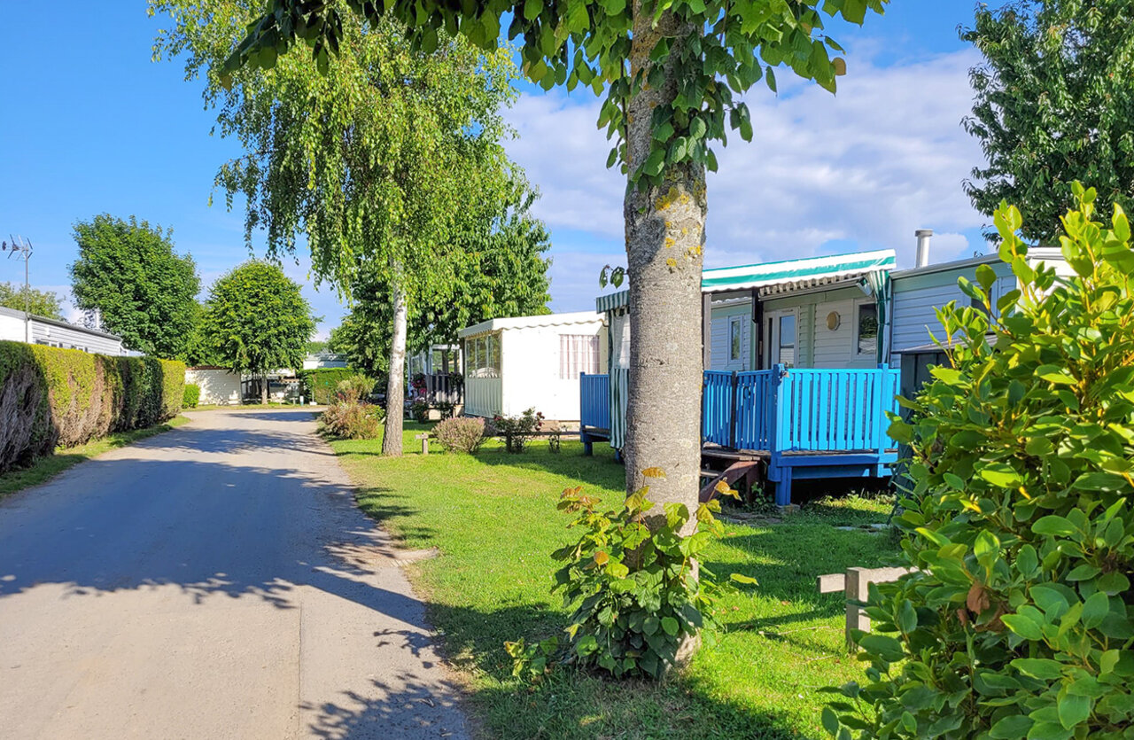 Mobilheime mit blauen Terrassen und gr�ner Allee bei CLICOCHIC Brise de Cabourg.