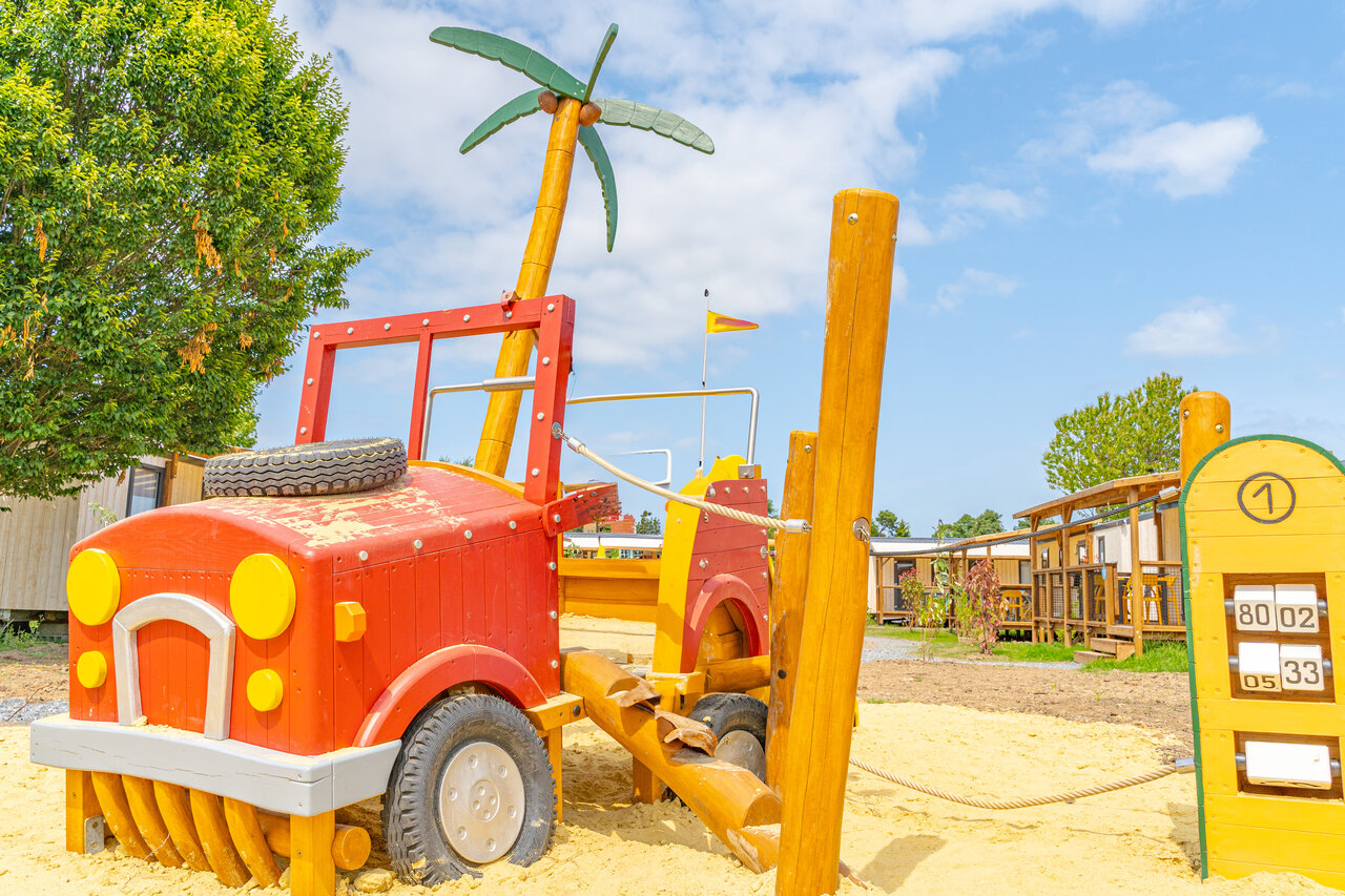 Spielplatz mit Holzauto und Palme f�r Kinder auf dem Campingplatz CLICOCHIC Brise de Cabourg in Varaville (14).