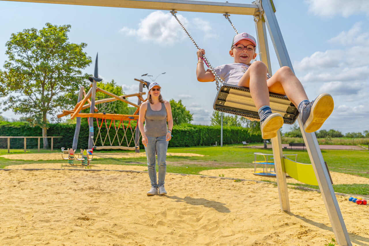 L�chelndes Kind auf Schaukel, Spielplatz auf Camping CLICOCHIC Brise de Cabourg (14).