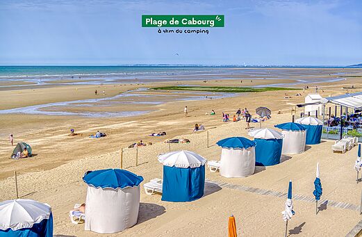 Groot zandstrand van Cabourg met strandcabines, te bezoeken nabij de camping.
