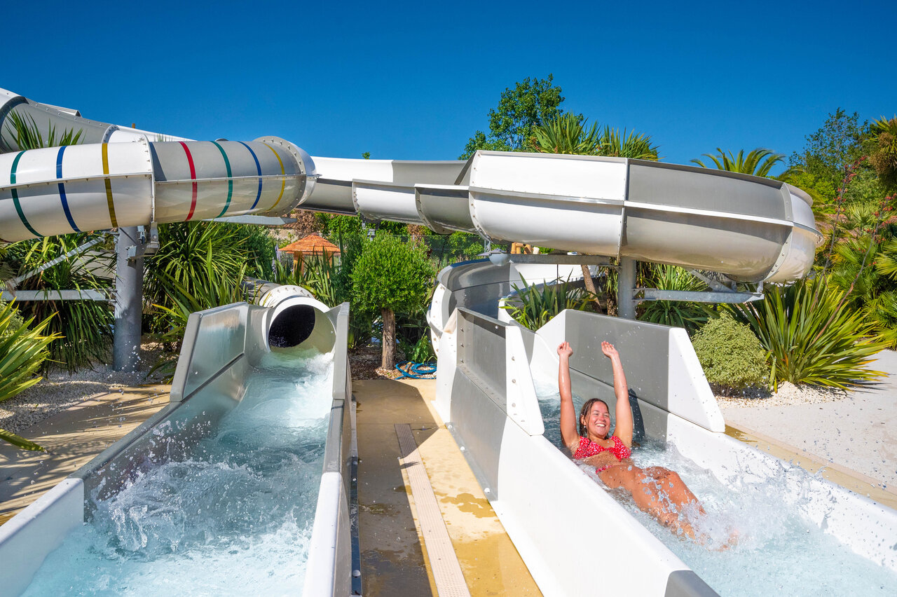 Lachende vrouw op waterglijbaan bij camping CLICOCHIC Cabanes d Ol�ron in ST GEORGES D'OLERON.