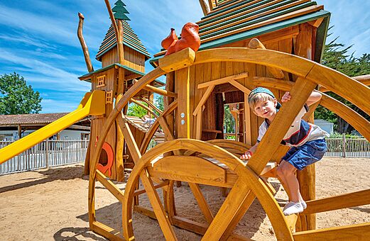 Holzspielplatz mit Rutsche und Kind auf dem Campingplatz CLICOCHIC Cabanes d Ol�ron in ST GEORGES D'OLERON (17).