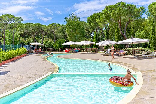 Outdoor swimming pool with lazy river and children playing at CAPFUN Campo dei Fiori campsite in Rosignano Marittimo (57).