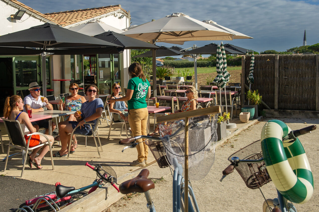 Levendig buitenterras van de bar op camping CLICOCHIC Camp du Soleil.