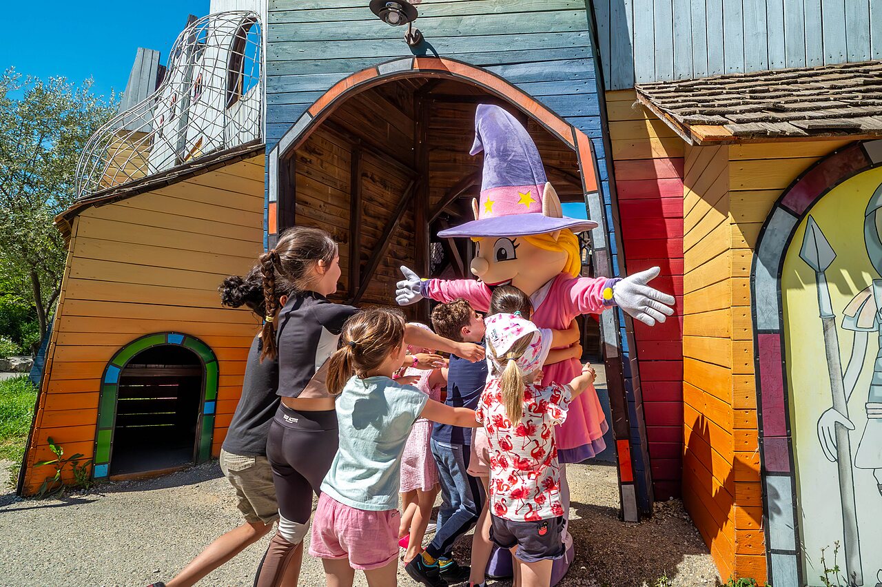 Kinder umarmen das Maskottchen des Campingplatzes CAPFUN Carpe Diem in VAISON LA ROMAINE.
