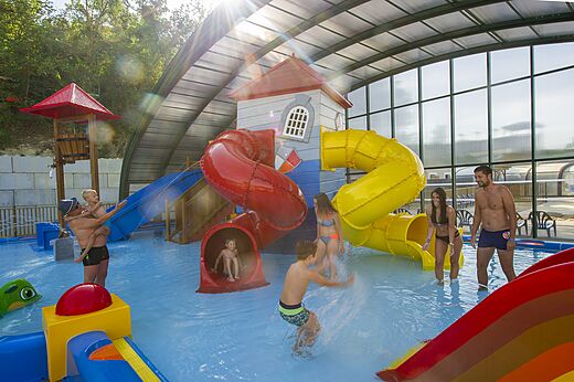 Wasserrutschen und Wasserspiele im überdachten Pool des Campingplatzes CAPFUN Carpe Diem.