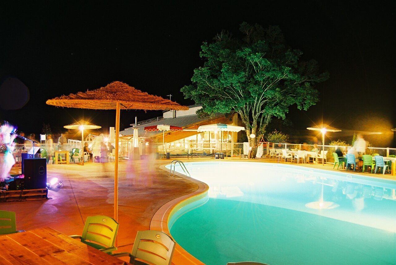 Beleuchteter Pool und Abendunterhaltung im Camping CLICOCHIC Castillon de Provence (04).