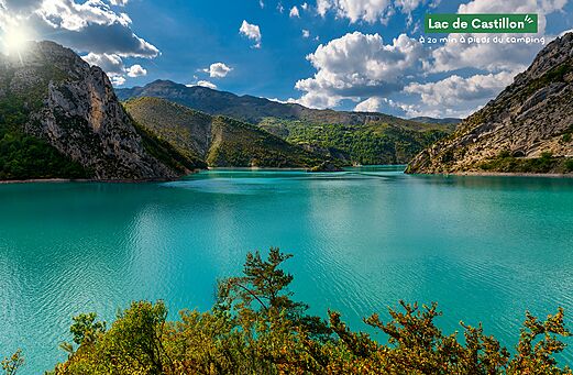 Lac de Castillon mit türkisfarbenem Wasser, umgeben von grünen Bergen bei Castellane.