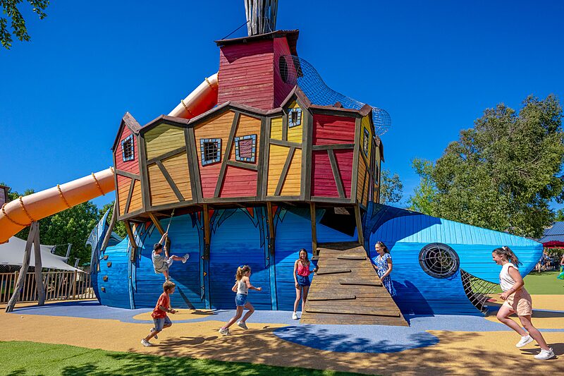 Carabouille Spielplatz - Gro�e bunte Spielstruktur mit Rutsche und Kindern auf dem Campingplatz CAPFUN Cenic in PENESTIN (56).