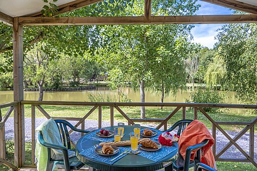 Terrasse Mobilheim mit Frühstück, Blick auf Teich am Camping CAPFUN Cenic in PENESTIN (56).