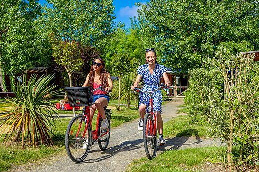 Zwei Frauen radeln auf gr�nem Weg im Camping CAPFUN Cenic in PENESTIN (56).