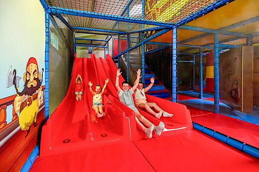 Indoor-Spielplatz mit Rutschen und Kindern auf dem Campingplatz CAPFUN Cenic in PENESTIN (56).