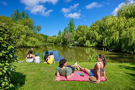 Familie entspannt am grünen Teich auf dem Campingplatz CAPFUN Cenic in PENESTIN (56).