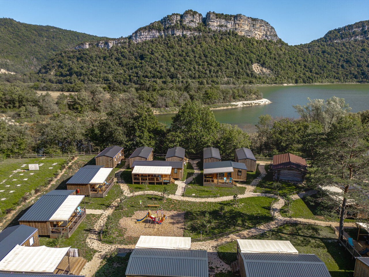 Aerial view accommodations, lake and playground at CLICOCHIC Chancia campsite in Chancia (01).