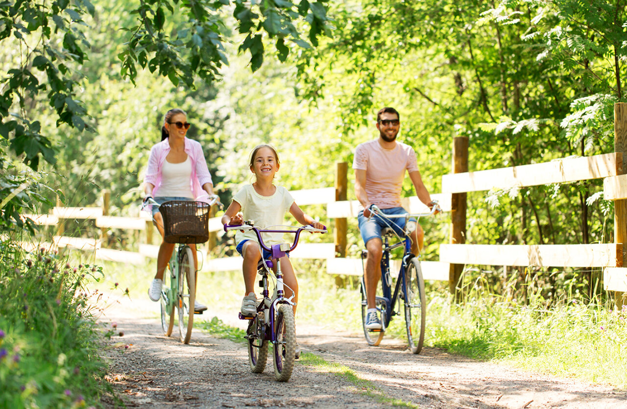 Familie fietst op bospad bij camping VAGUES OCEANES Domaine les Charmilles.