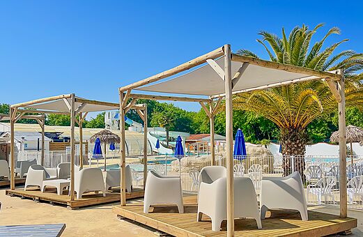 Schwimmbad, Rutschen und St�hle unter Pergolen auf dem Campingplatz VAGUES OCEANES Domaine les Charmilles in Saint-Laurent-de-la-Pr�e (17).