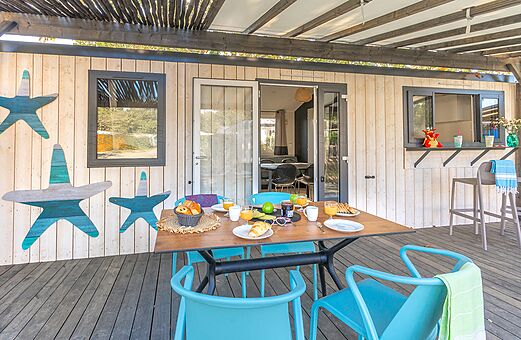 Terrasse Mobilheim mit Fr�hst�ck auf dem Campingplatz VAGUES OCEANES Domaine les Charmilles in Saint-Laurent-de-la-Pr�e (17).