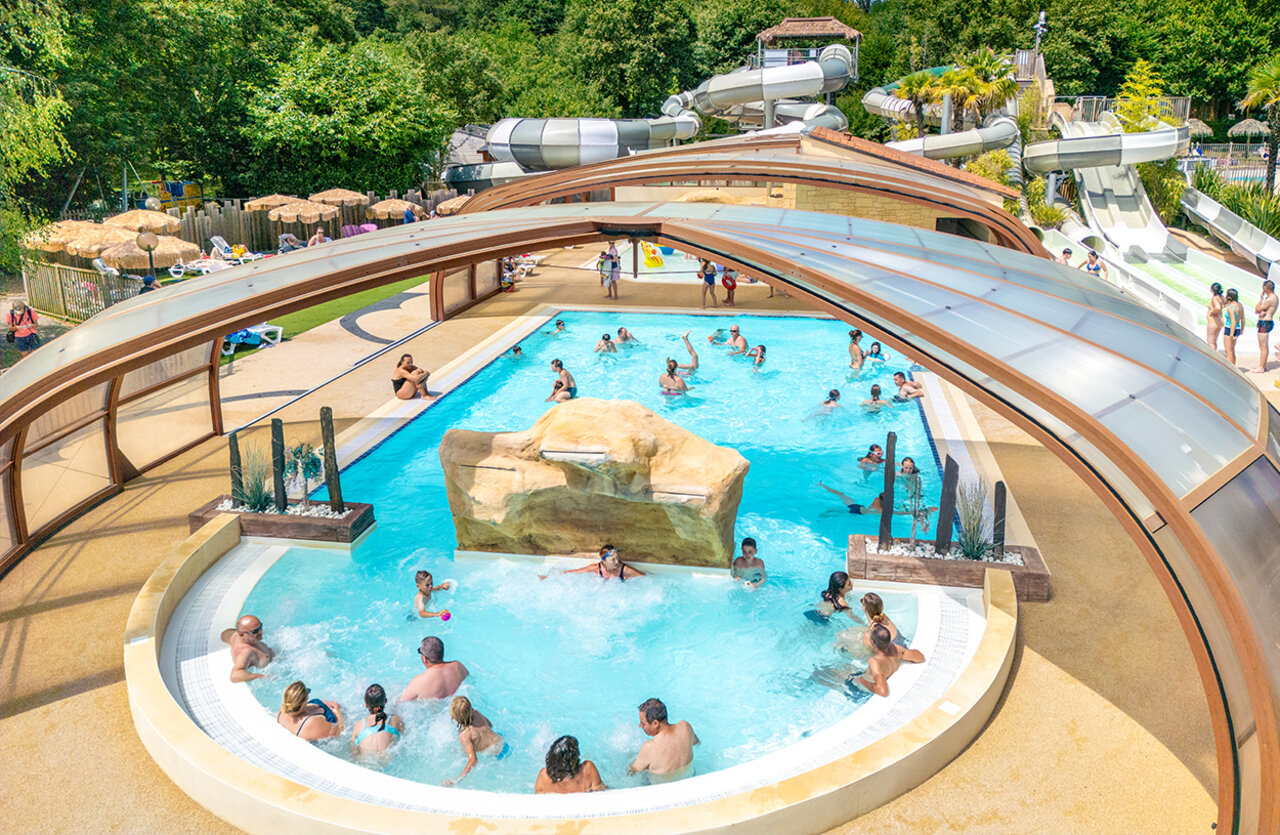 Outdoor pools, water slides and jacuzzi at VAGUES OCEANES Chataigneraie campsite, Prats-de-Carlux.