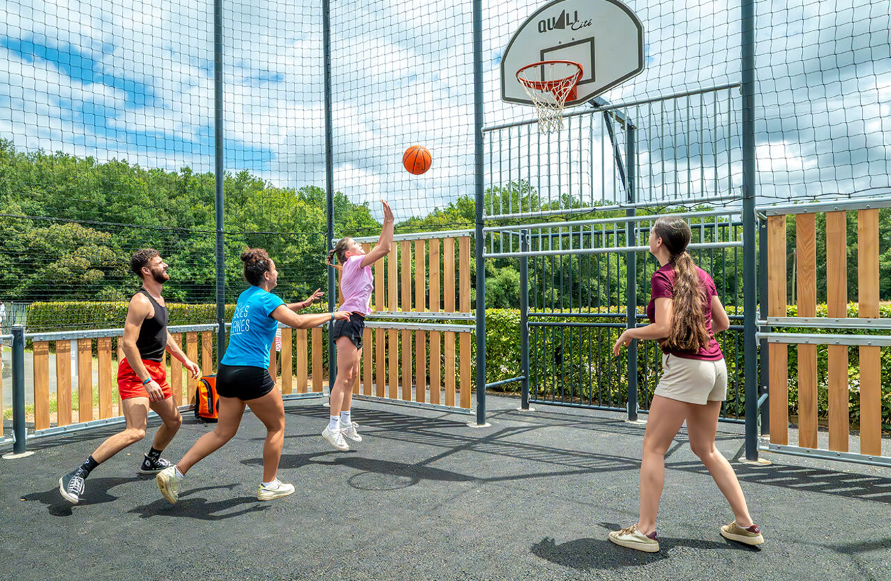 Multisport basketball court with young people at camping VAGUES OCEANES Chataigneraie in Prats-de-Carlux.