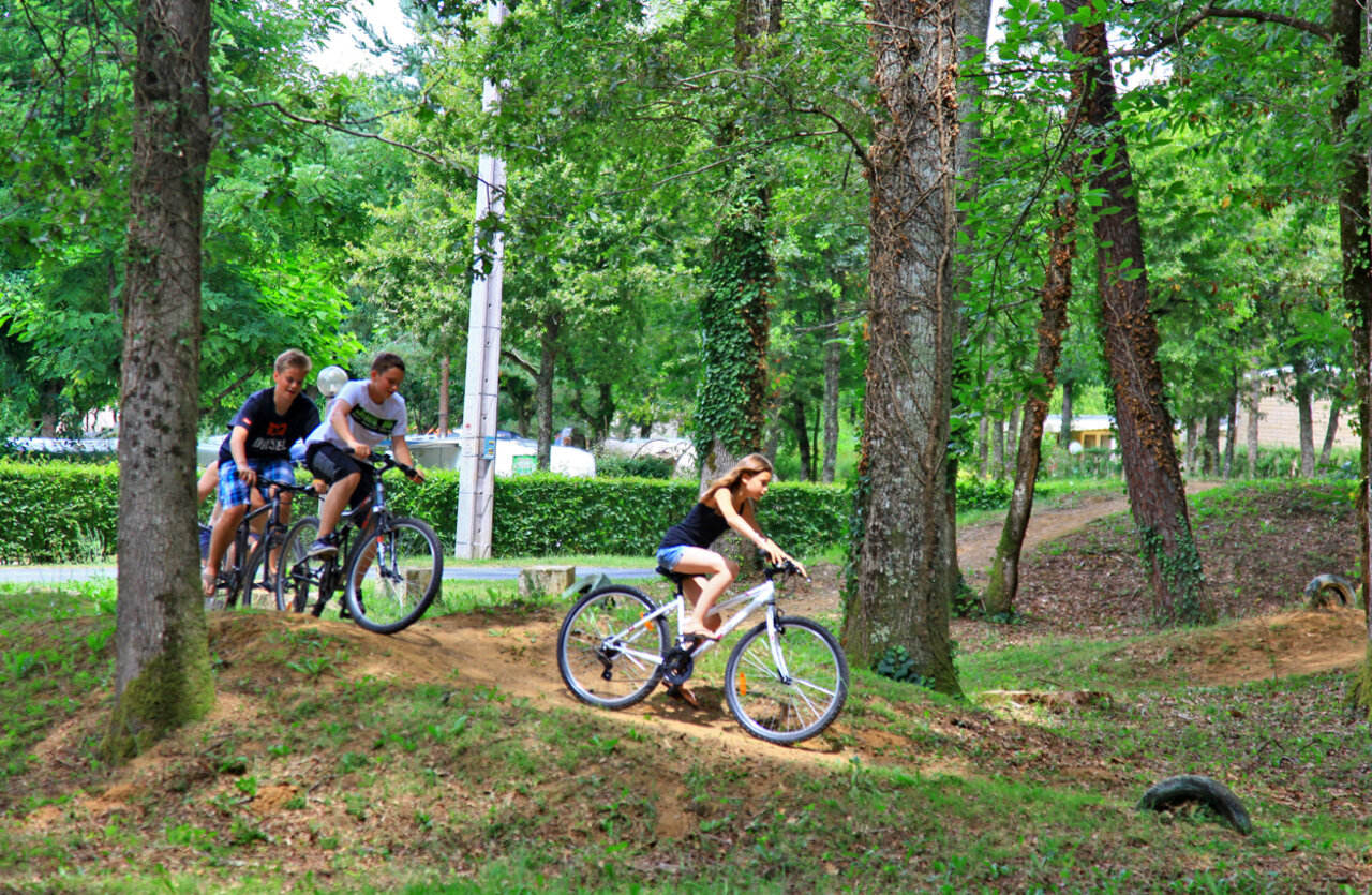 Young cyclists on trail at VAGUES OCEANES Chataigneraie campsite Prats-de-Carlux.