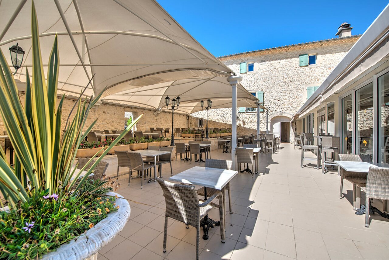 Terrasse ombrag�e du restaurant et bar, tables, au camping CLICOCHIC Ch�teau de Boisson (30).