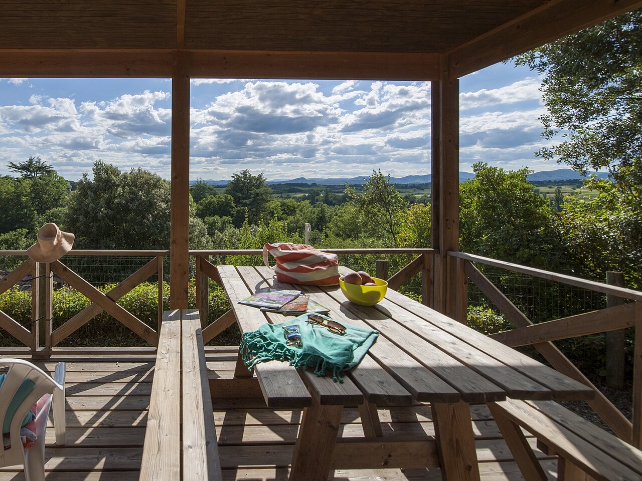 Terrasse en bois, table, vue panoramique au camping CLICOCHIC Ch�teau de Boisson.
