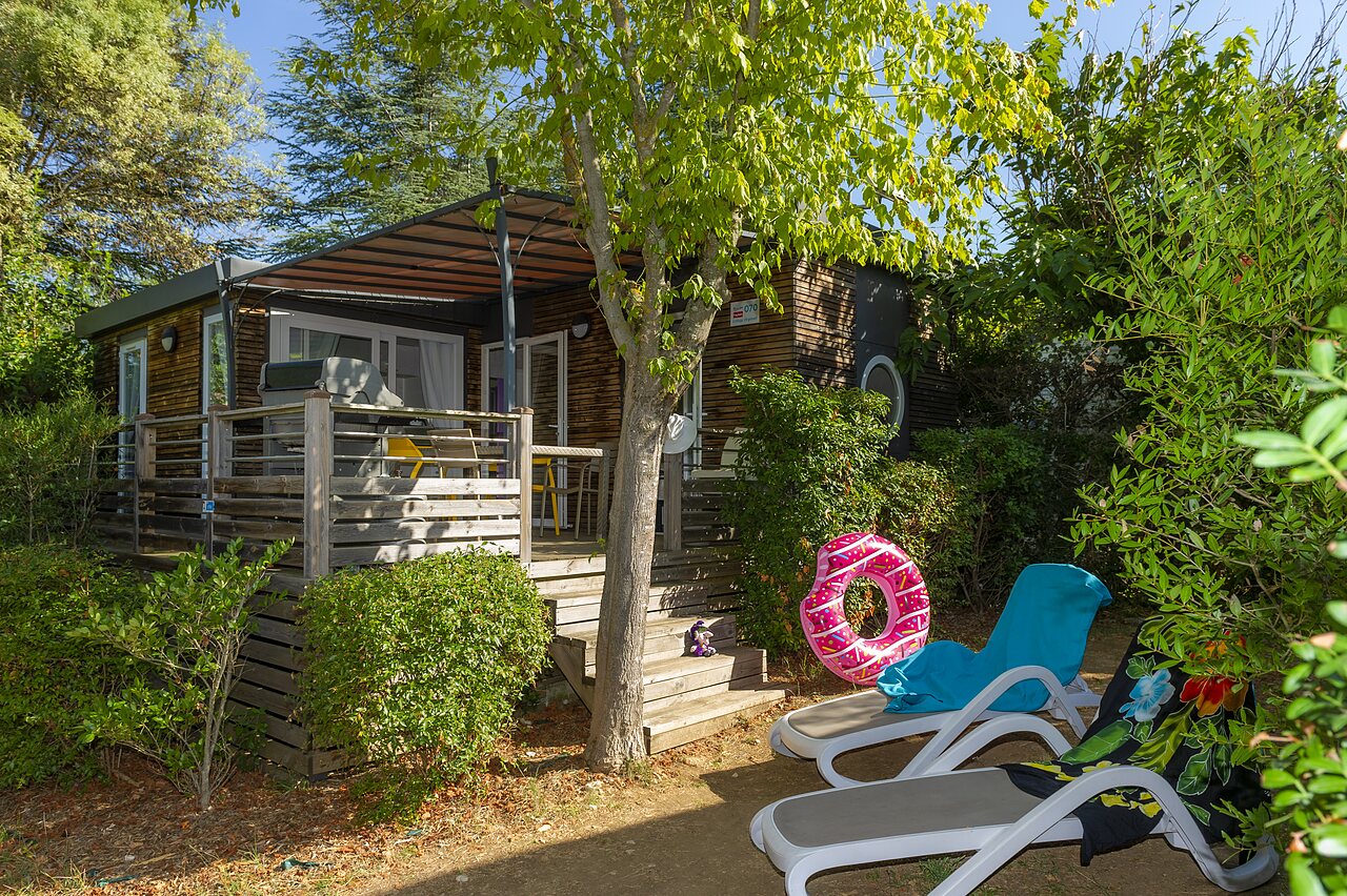 Mobile home en bois, terrasse, transats au camping CLICOCHIC Ch�teau de Boisson � All�gre-les-Fumades (30).