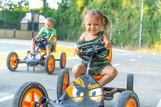 Enfants souriants sur karts � p�dales au camping CLICOCHIC Ch�teau de Boisson � All�gre-les-Fumades (30).