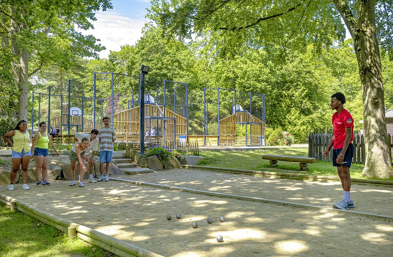 Jongeren spelen jeu de boules, multisportterrein op de achtergrond op camping CAPFUN Ch�teau de Galin�e in SAINT CAST LE GUILDO (22).