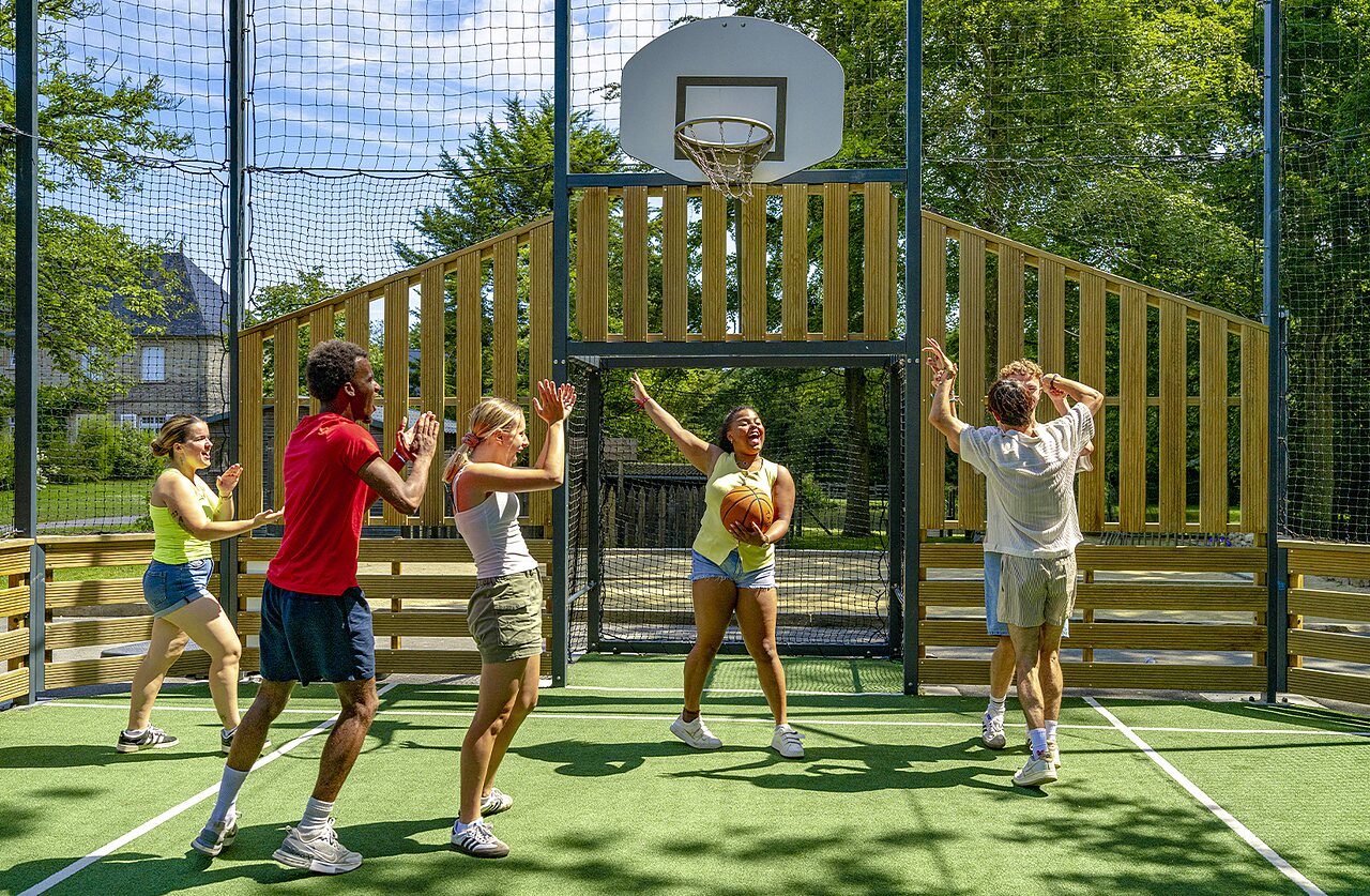 Jongeren basketballen op het multisportterrein van camping CAPFUN Ch�teau de Galin�e.
