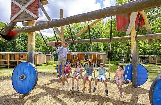 Large unique swing set with smiling children at CAPFUN Ch�teau de Galin�e campsite in SAINT CAST LE GUILDO (22).