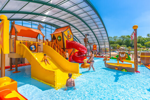 Überdachter Wasserspielplatz mit Rutschen und Kindern auf CAPFUN Chateau d'Arvid in Villerville (14).