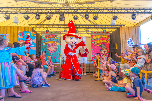 Animation avec mascotte et enfants sur scène au camping CAPFUN Chateau d'Arvid à Villerville (14).