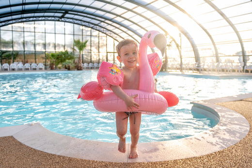 Überdachter Pool, Kind mit rosa Flamingo Schwimmring, CAPFUN Chateau d'Arvid Villerville.