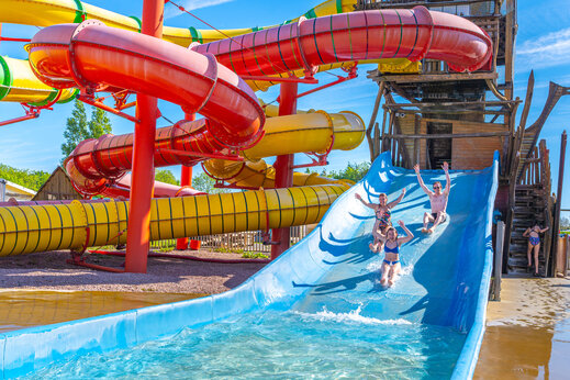 Bunte Wasserrutschen und lachende Menschen auf dem Campingplatz CAPFUN Chateau d'Arvid in Villerville.