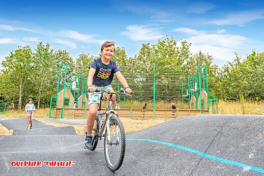 Pump track und Kind auf Fahrrad auf dem Campingplatz CAPFUN La Chênaie, PORNIC (44).