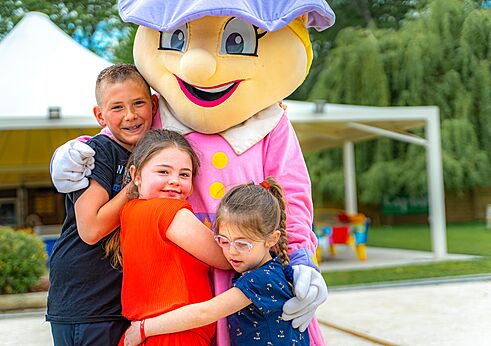 Campingmaskottchen umarmt lachende Kinder auf CAPFUN La Chênaie PORNIC (44).
