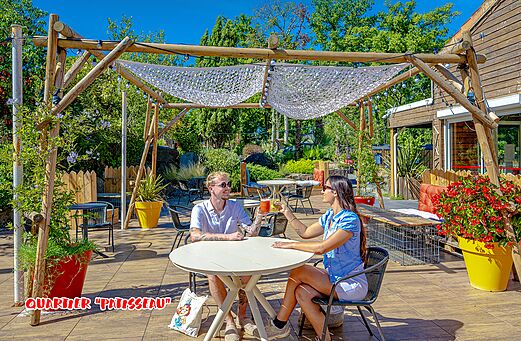 Schattige Restaurantterrasse mit Paar auf dem Campingplatz CAPFUN La Chênaie in PORNIC (44).
