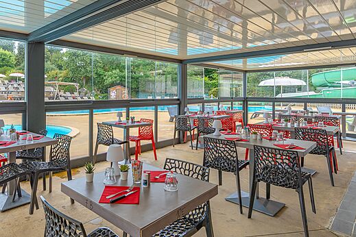 Modernes Restaurant mit Tischen und Stühlen am Pool auf dem Campingplatz CAPFUN La Chênaie in PORNIC (44).